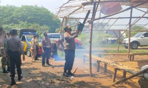 Kapolsek Ngoro Kompol Subiyanto menggergaji bambu yang dijadikan tempat judi sabung ayam