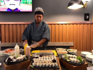 Chef Nova sedang menyajikan sushi rendang dan sushi pecel