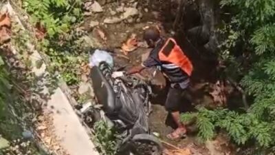 Petugas kepolisian dibantu warga mengevakuasi motor korban dari dasar sungai, Minggu (1/10/2023). (Hasan/KabarTerdepan.com) 