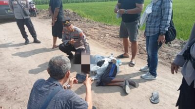 Petugas Polsek Trowulan melakukan evakuasi jasad pengamen, Senin (16/10/2023). (Erik/KabarTerdepan.com) 