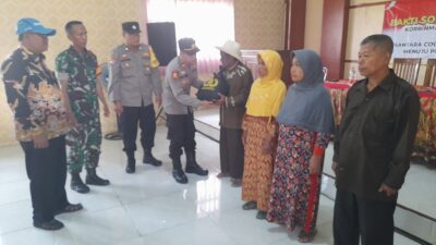 Kapolsek Dlanggu Iptu Muhammad Khoirul Umam menyerahkan bantuan sembako kepada warga, Jumat (8/12/2023). (Dok. Polsek Dlanggu) 