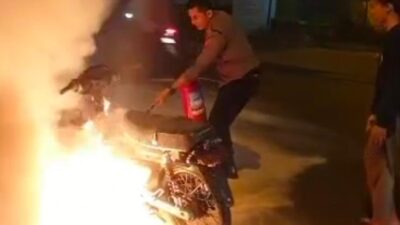 Aksi heroik anggota Samapta Polres Mojokerto, Apitu Arik Hidayat memadamkan sebuah motor yang terbakar yang berada di area SPBU Mojosari (Lintang / Kabarterdepan.com)