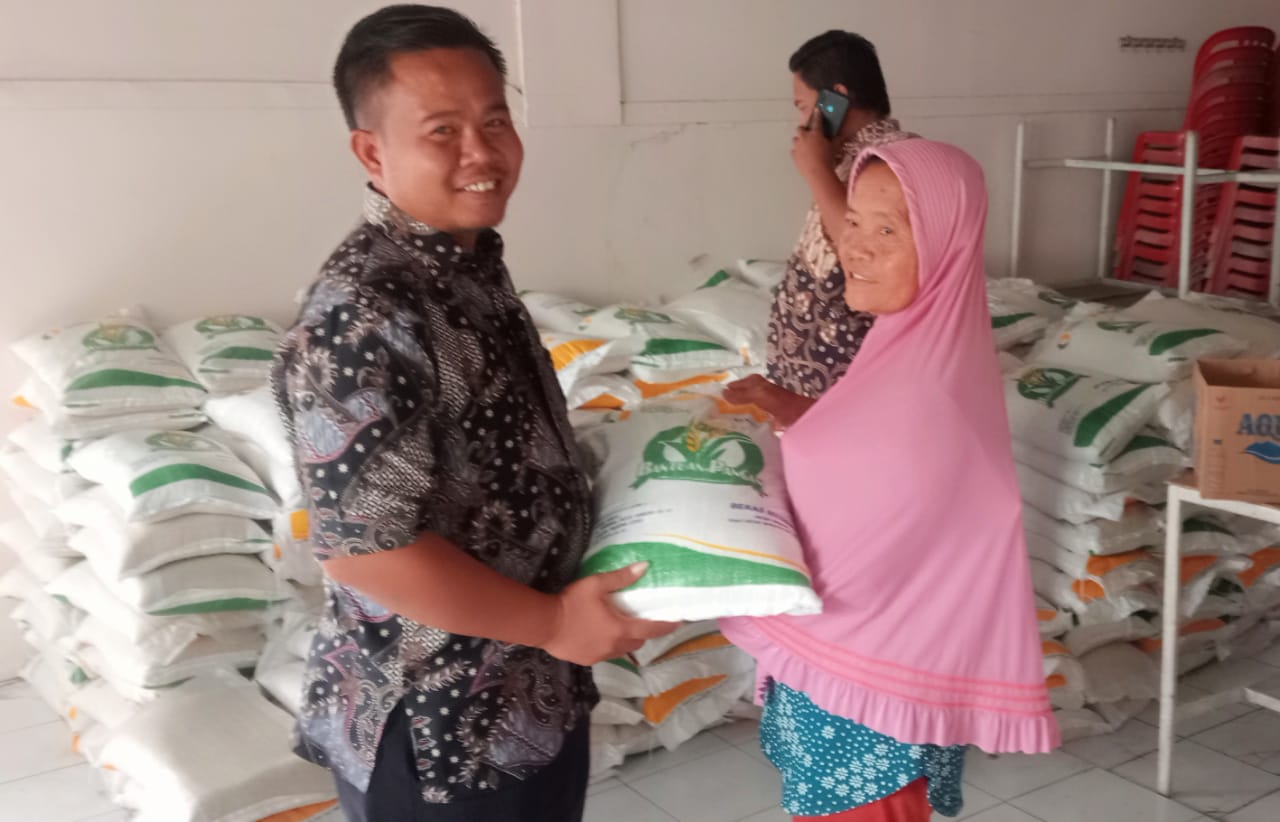 Penyaluran bantuan beras oleh Kades Sentot Nugraha kepada Keluarga Penerima Manfaat (KPM). (Masrikin/kabarterdepan.com)