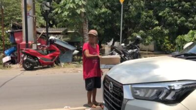 Salah satu warga yang berada di tengah jalan untuk meminta bantuan ke pengendara (Redaksi Kabarterdepan.com)