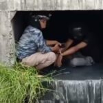 Salah seorang terduga pencuri diborgol polisi di saluran air di Kedung Cowek Surabaya untuk menghindari amukan massa, Senin (18/3/2024). (Catur/kabarterdepan.com)