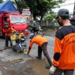 Sejumlah pekerja dari Dinas Bina Marga saat menambal jalan yang rusak akibat banjir. (Ahmad/kabarterdepan.com)