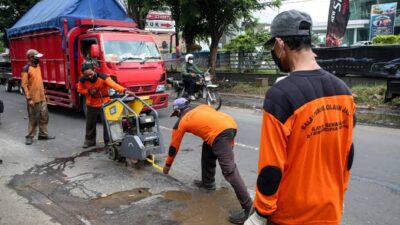 Sejumlah pekerja dari Dinas Bina Marga saat menambal jalan yang rusak akibat banjir. (Ahmad/kabarterdepan.com)