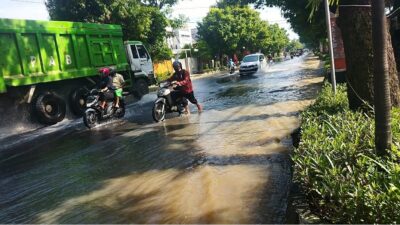Salah seorang pengguna jalan yang sepeda motornya mogok akibat terjang banjir. (Redaksi/kabarterdepan.com) 