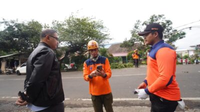 Pj Wali Kota Batu Aries Agung Paewai, saat mendampingi Tim Reaksi Cepat BPBD Pemkot Batu membersihkan sisa pohon tumbang akibat angin kencang, Selasa (12/3/2024). (Yan/kabarterdepan.com)