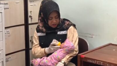 Bupati Mojokerto Ikfina Fahmawati saat memberikan susu formula kepada bayi mungil yang dibuang orang tuanya. (Redaksi/kabarterdepan.com)