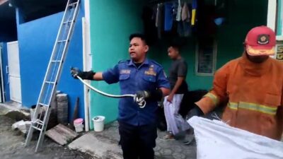 Petugas Damkar yang berhasil mengevakuasi ular kobra dari rumah warga. (Redaksi/kabarterdepan.com)