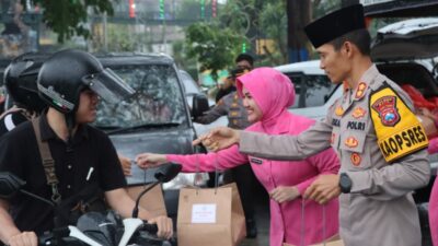 Kapolres Kota Batu AKBP Oskar Syamsuddin dan Ketua Bhayangkari membagiakan takjil kepada pengguna jalan. (Yan/kabarterdepan.com)