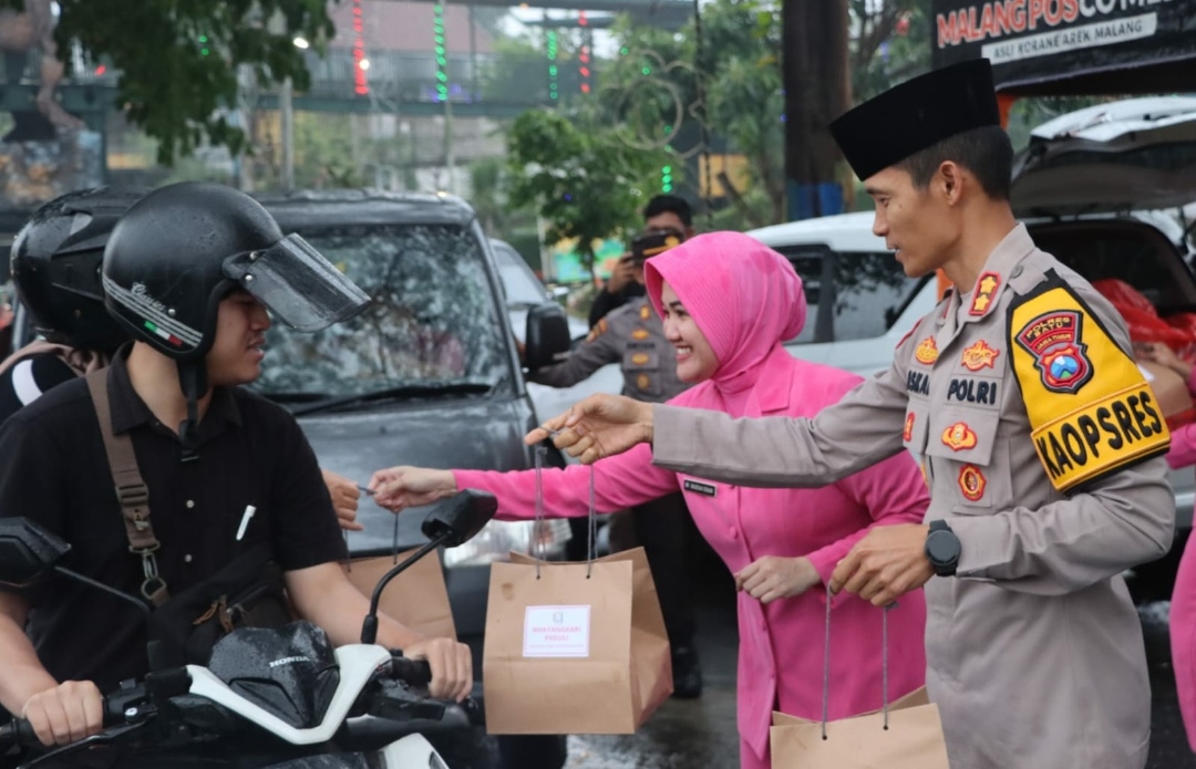 Kapolres Kota Batu AKBP Oskar Syamsuddin dan Ketua Bhayangkari membagiakan takjil kepada pengguna jalan. (Yan/kabarterdepan.com) 