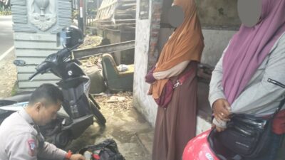 Anggota Satlantas Polres Kota Batu, Aipda Deddy saat mengamankan 2 wanita terduga pencuri baju, Sabtu (30/3/2024). (Yan/kabarterdepan.com)