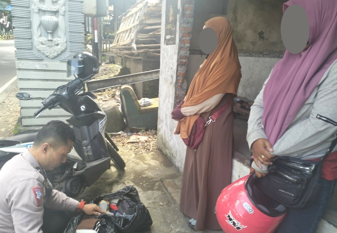 Anggota Satlantas Polres Kota Batu, Aipda Deddy saat mengamankan 2 wanita terduga pencuri baju, Sabtu (30/3/2024). (Yan/kabarterdepan.com) 