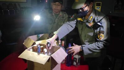 Petugas Satpol PP Kabupaten Mojokerto saat mengamankan puluhan botol minuman keras. (Redaksi/kabarterdepan.com)