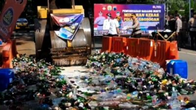 Ribuan botol miras dimusnahkan dengan dilindas alat berat. (Masrikin/kabarterdepan.com)