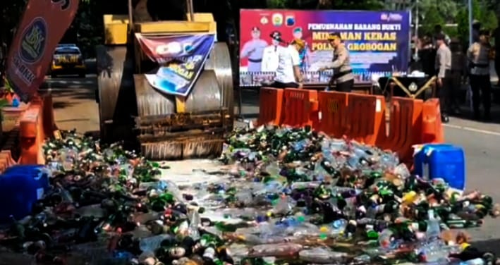 Ribuan botol miras dimusnahkan dengan dilindas alat berat. (Masrikin/kabarterdepan.com) 