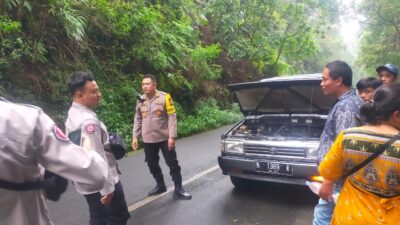 Anggota Polres Mojokerto memberikan bantuan terhadap pemudik yang kendaraannya mogok, Minggu (14/4/2024). (Humas Polres Mojokerto)