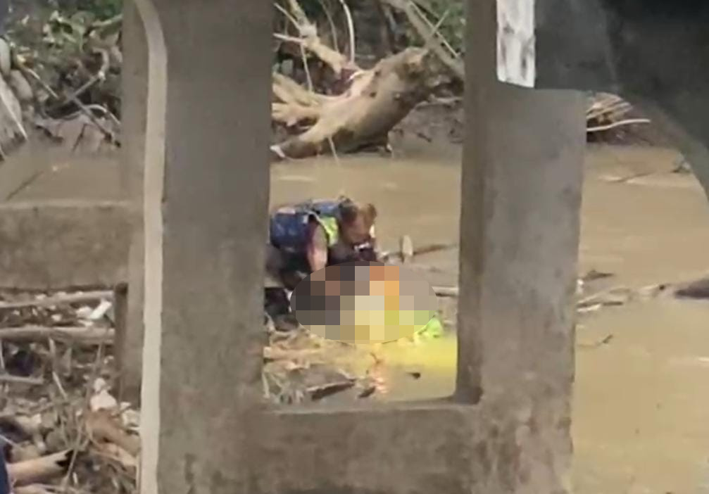 Relawan TKP Birunya Cinta, Jaenal Abidin mengevakuasi bayi di aliran Sungai Marmoyo (Tangkapan layar video)