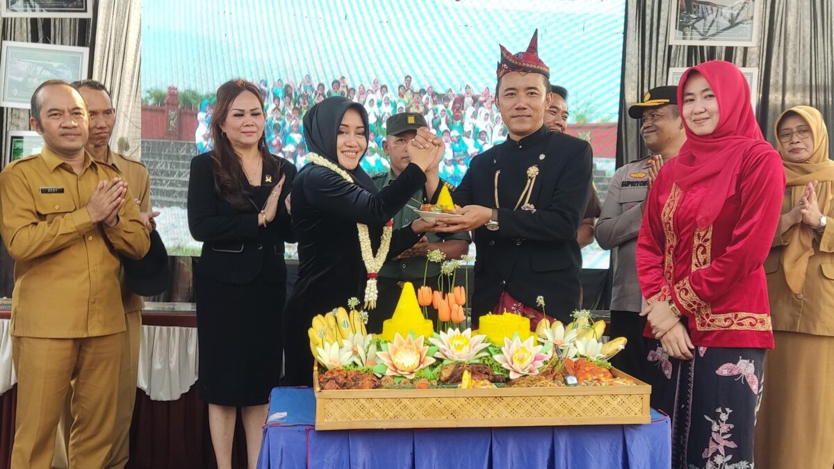 Bupati Ikfina memberikan potongan tumpeng kepada Pj kepala desa Mojokumpul Nicki Socrates saat prosesi peresmian RTH. (Alief Wahdana/kabarterdepan.com) 