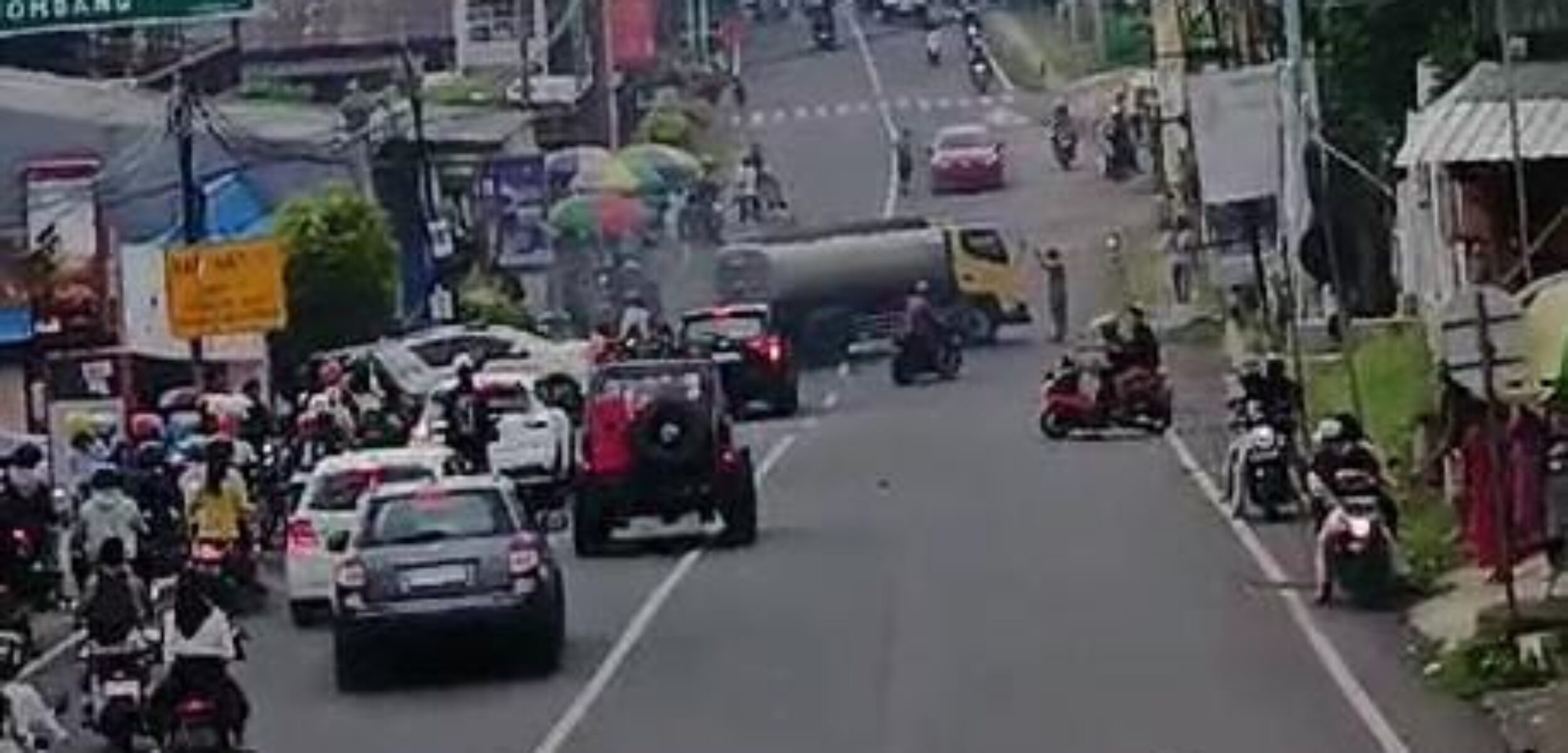 Terlihat truk tangki berada di tengah tengah jalan raya Pacet usai hendak dihajar segerombolan pemuda berkaos hitam (Tangkapan layar video)