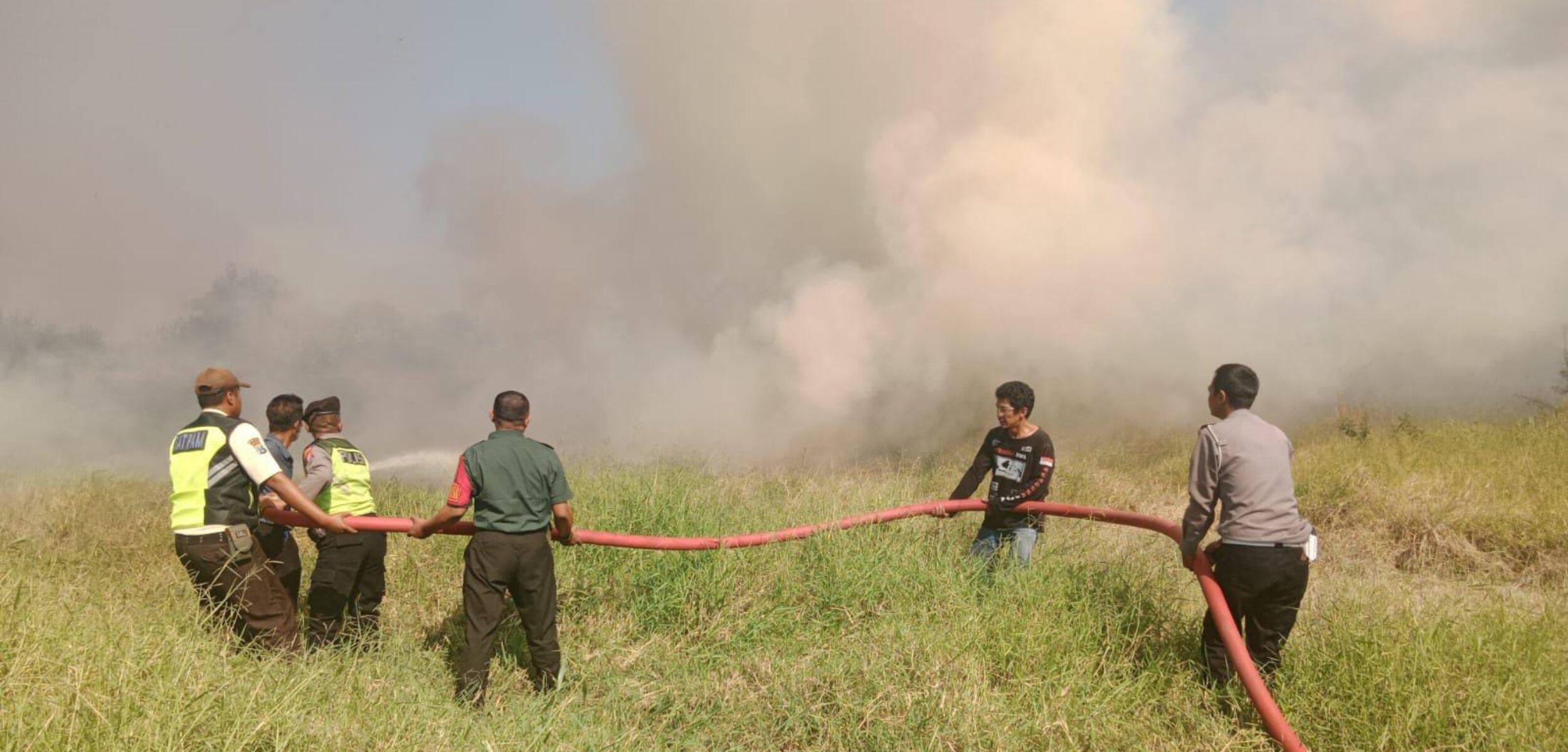 Petugas berusaha memadamkan api di 2 lahan kosong, Selasa (16/7/2024) siang (Andy / Kabarterdepan.com)
