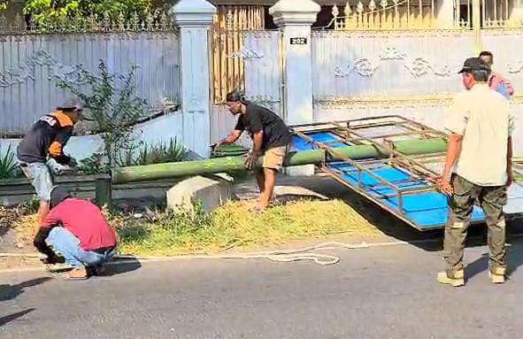 Petugas Satpol PP Kabupaten Mojokerto merobohkan reklame di Jalan Raya Pacing Kecamatan Bangsal, Kabupaten Mojokerto (Andy / Kabarterdepan.com)