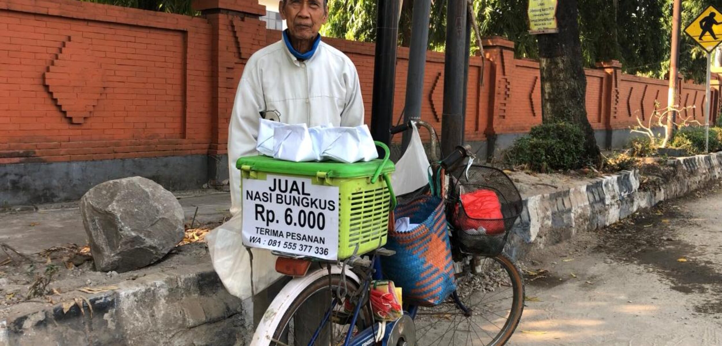 Khoderi, penjual nasi bungkus yang motornya hilang karena direndam sedang berjualan di Mojosari, Senin (29/7/2024) pagi (Andy / Kabarterdepan.com) 
