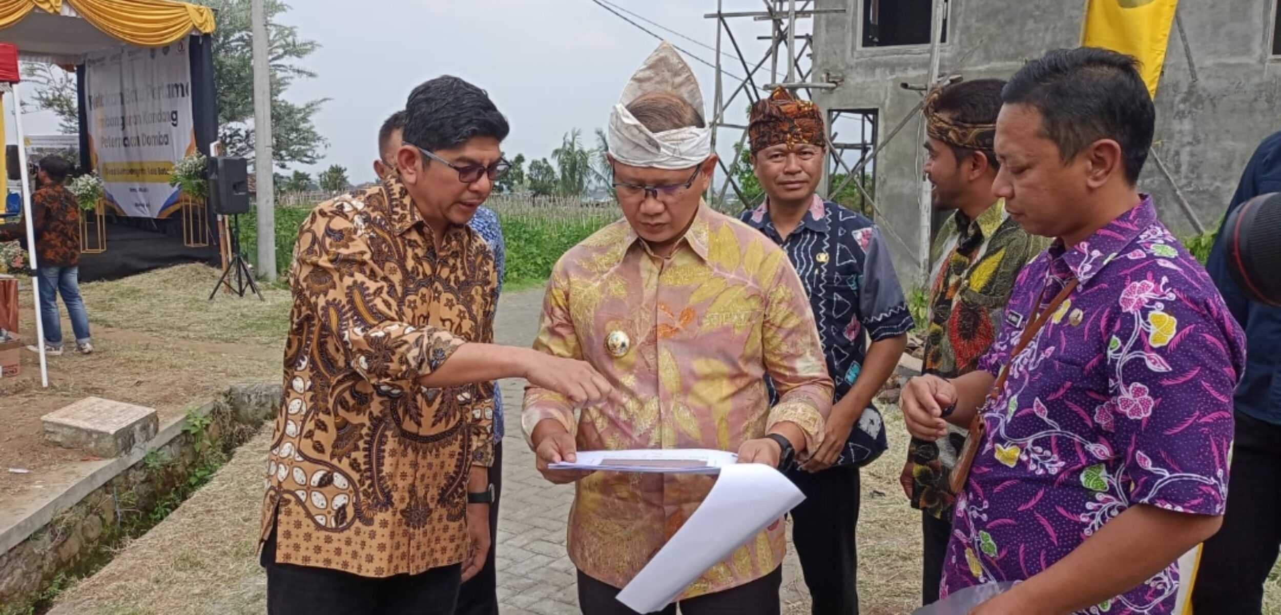 Pj. Wali Kota Batu Aries Agung Paewai, bersama Branch Office Head PT. United Tractors, Badrun Radi, saat tengah melihat site plan pembangunan kandang peternakan domba di Desa Sumbergondo. (Yan)