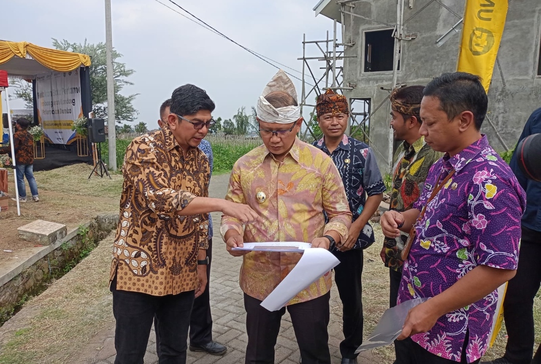 Pj. Wali Kota Batu Aries Agung Paewai, bersama Branch Office Head PT. United Tractors, Badrun Radi, saat tengah melihat site plan pembangunan kandang peternakan domba di Desa Sumbergondo. (Yan)