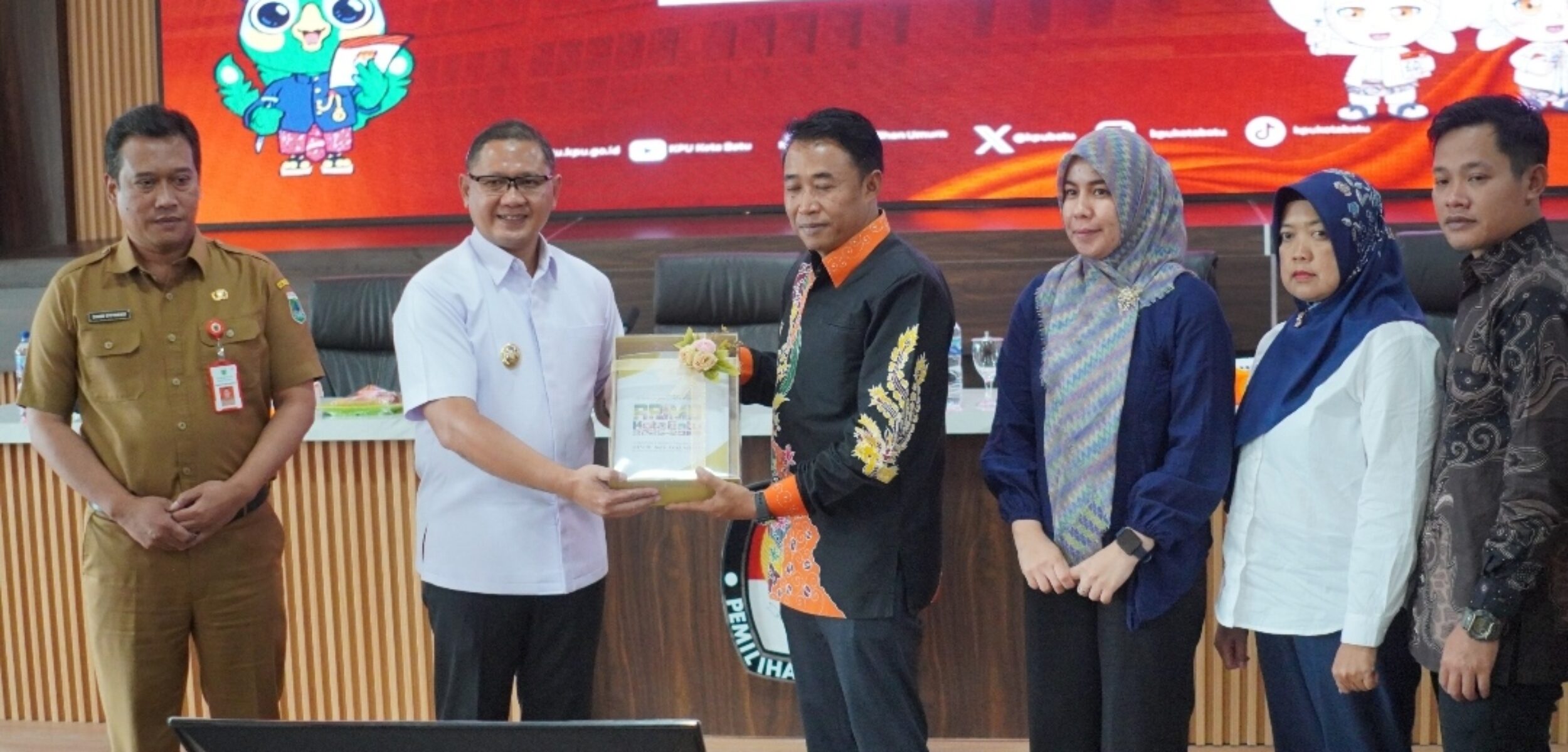 Pj. Wali Kota Batu Aries Agung Paewai, saat menyerahkan dokumen rancangan teknokratik kepada Ketua KPU Heru Joko Purwanto. (Yan)