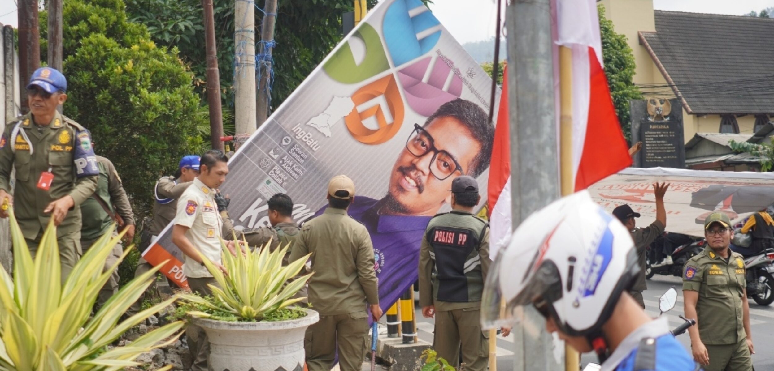 Satpol PP Kota Batu bersama petugas gabungan TNI-Polri, saat tengah menertibkan APK Parpol. (Yan)