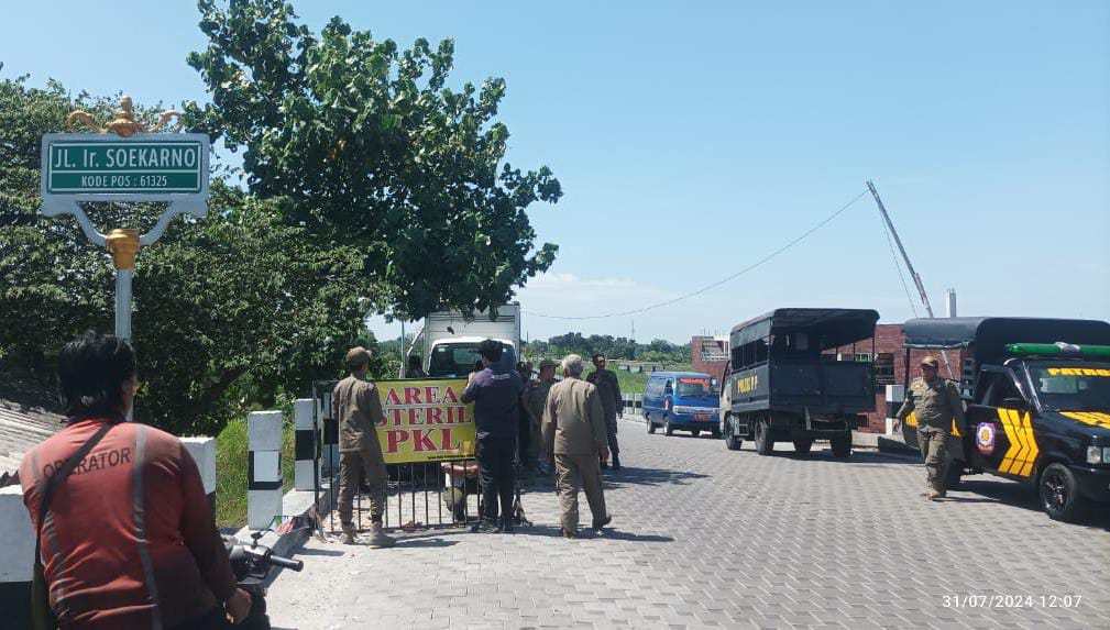 Petugas Satpol PP Kota Mojokerto memasang tulisan larangan PKL berjualan di sepanjang Jalan Ir Soekarno, Rabu (31/7/2024) sore (Andy / Kabarterdepan.com)