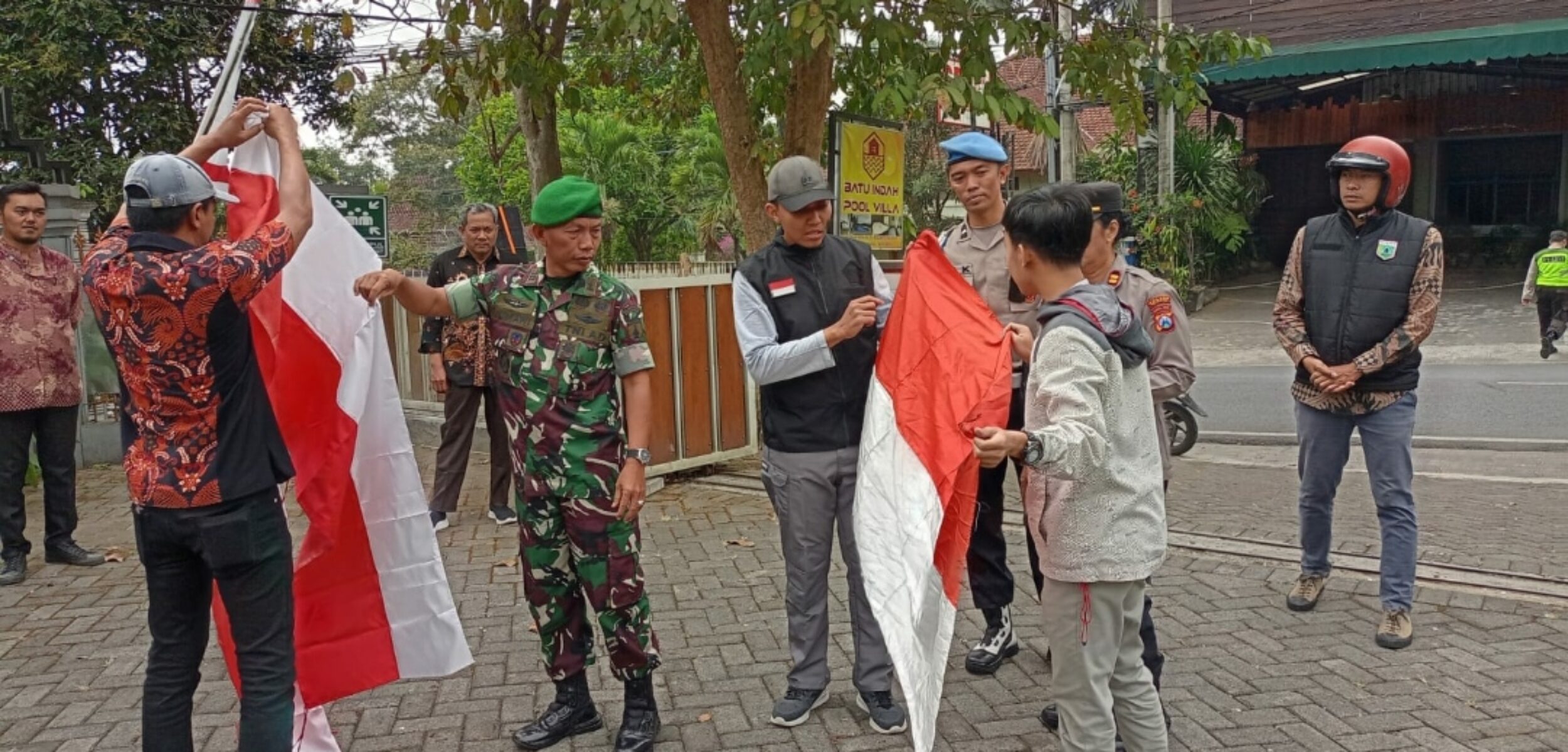 Camat Batu, Sasongko Fitra Aditama, S.IP., M.H bersama Danramil Batu, Kapolsek Batu dan Kesbangpol Pemkot Batu, saat tengah memberikan bendera merah putih gratis kepada masyarakat Kota Batu. (Yan)