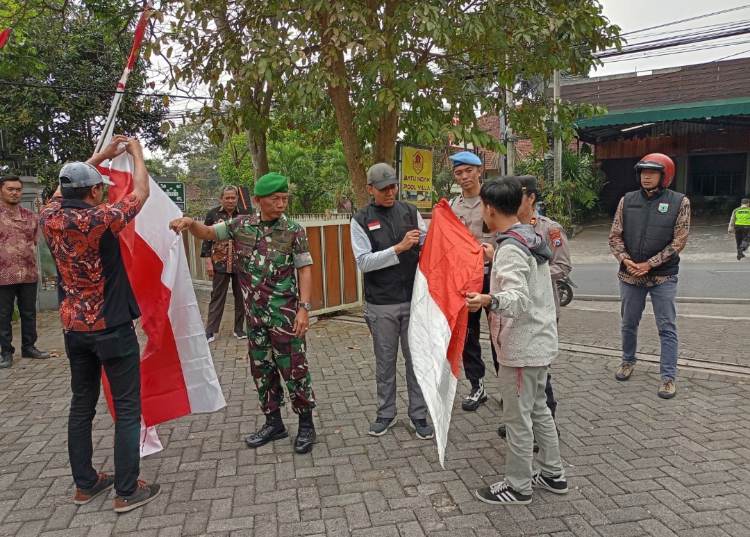 Camat Batu, Sasongko Fitra Aditama, S.IP., M.H bersama Danramil Batu, Kapolsek Batu dan Kesbangpol Pemkot Batu, saat tengah memberikan bendera merah putih gratis kepada masyarakat Kota Batu. (Yan)