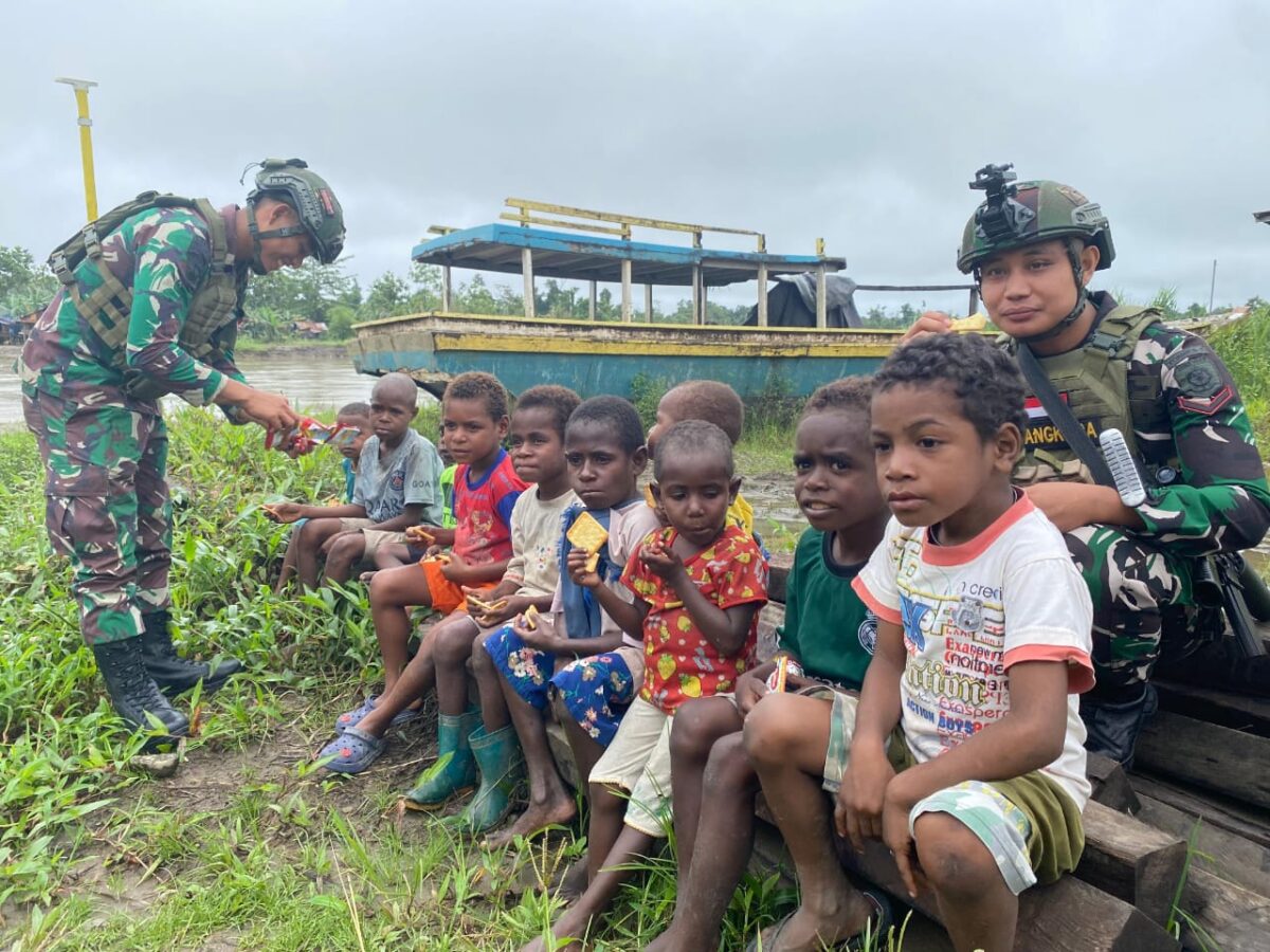 Satgas Pamtas Mobile RI-PNG Yonif 503/Mayangkara Koops Habema memberikan biskuit kepada anak-anak korban banjir di Papua (Dok. Satgas Pamtas Mobile RI-PNG Yonif 503/Mayangkara Koops Habema) 