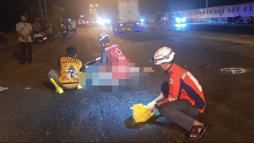 Petugas mengevakuasi jenazah korban, Dwi Bayu Saputro (37), asal Surabaya yang tewas setelah motornya menabrak truk, Minggu (27/10/2024) malam (Andy / Kabarterdepan.com)