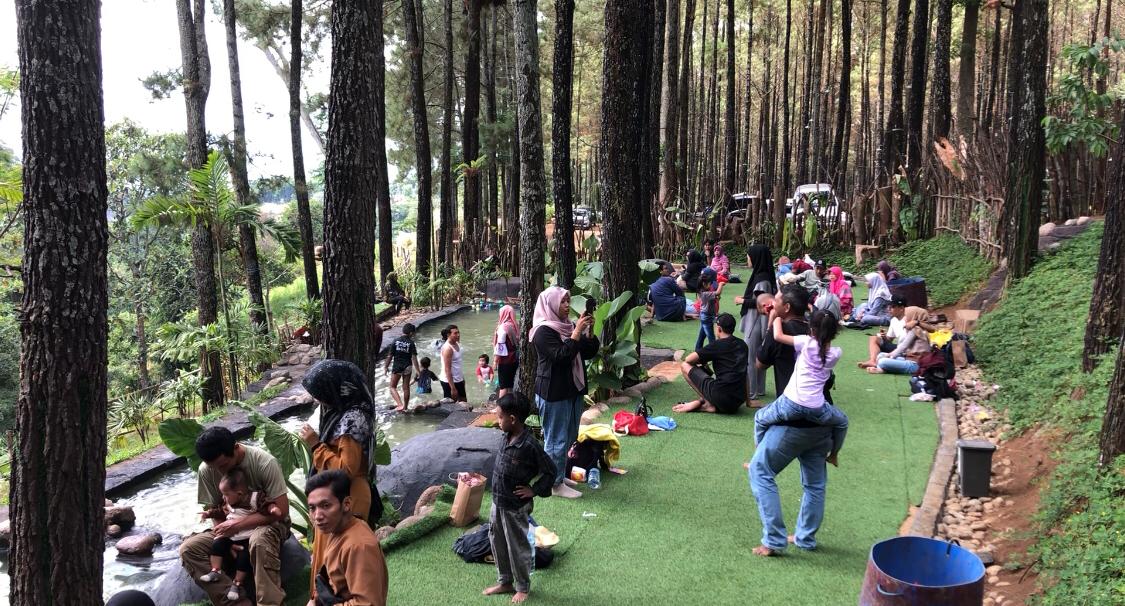 Pengunjung menikmati kolam renang dan air terjun buatan di kawasan hutan pinus milik Perhutani, Desa Trawas, Kecamatan Trawas, Kabupaten Mojokerto (Andy / Kabarterdepan.com)