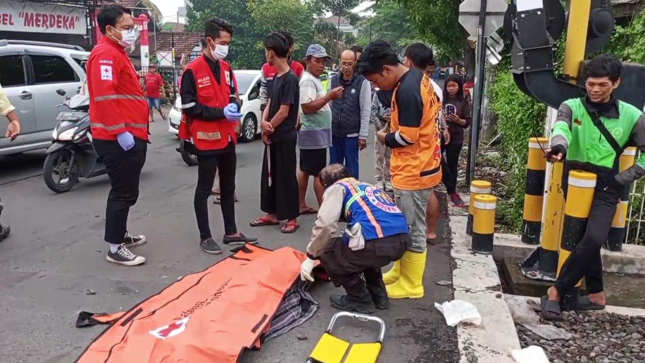 Warga dan relawan mengevakuasi jenazah korban laka KA di perlintasan kereta api, Jalan Raya Brawijaya, Kota Mojokerto (Andy / Kabarterdepan.com)