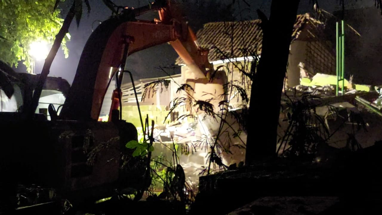 Alat berat membongkar material bangunan rumah polisi yang meledeak di Desa Sumolawang, Kecamatan Puri yang meledak dengan mendatangkan alat berat, Senin (13/1/2025) malam (Andy / Kabarterdepan.com) 