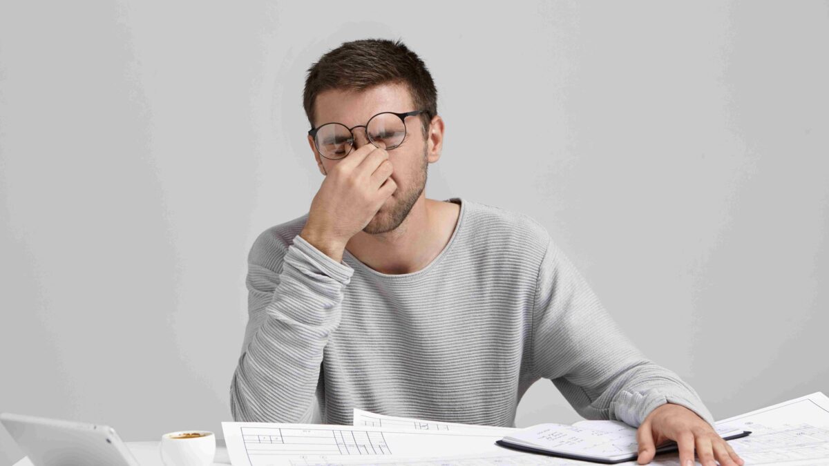 stess overwork deadline tired unshaven young architect freelancer massaging nose bridge 11zon scaled
