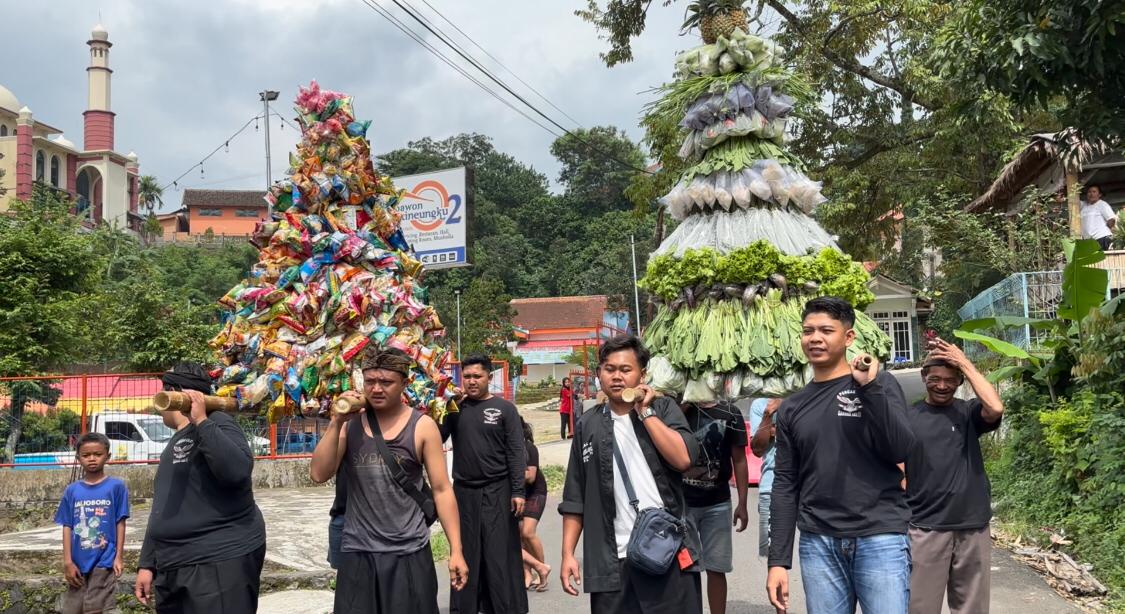 Puluhan warga mengarak gunungan hasil bumi saat kegiatan ruwah Dusun Pacet Barat, Desa Pacet, Kecamatan Pacet, Kabupaten Mojokerto, Sabtu (15/2/2025) sore (Redaksi / Kabarterdepan.com) 