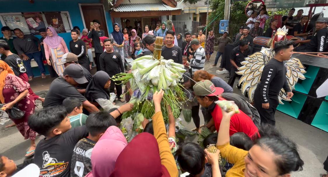 Ratusan warga berebut gunungan hasil bumi saat kegiatan ruwah Dusun Pacet Barat, Desa Pacet, Kecamatan Pacet, Kabupaten Mojokerto, Sabtu (15/2/2025) sore (Redaksi / Kabarterdepan.com) 