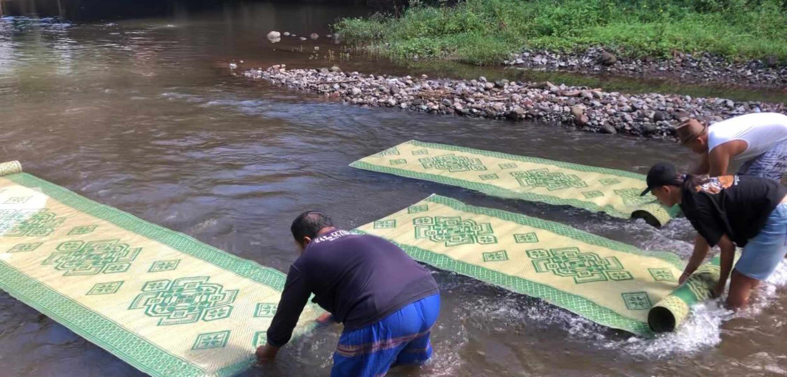 Proses cuci tikar di aliran sungai Kromong, Kecamatan Pacet, Kabupaten Mojokerto, Minggu (23/2/2025) pagi (Redaksi / Kabarterdepan.com) 