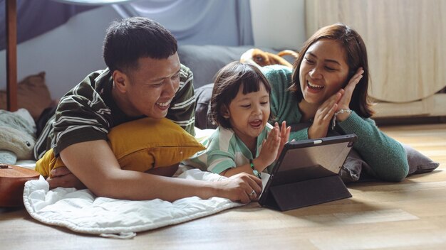 happy asian family little daughter are lying floor home watching tablet together 368093 13220