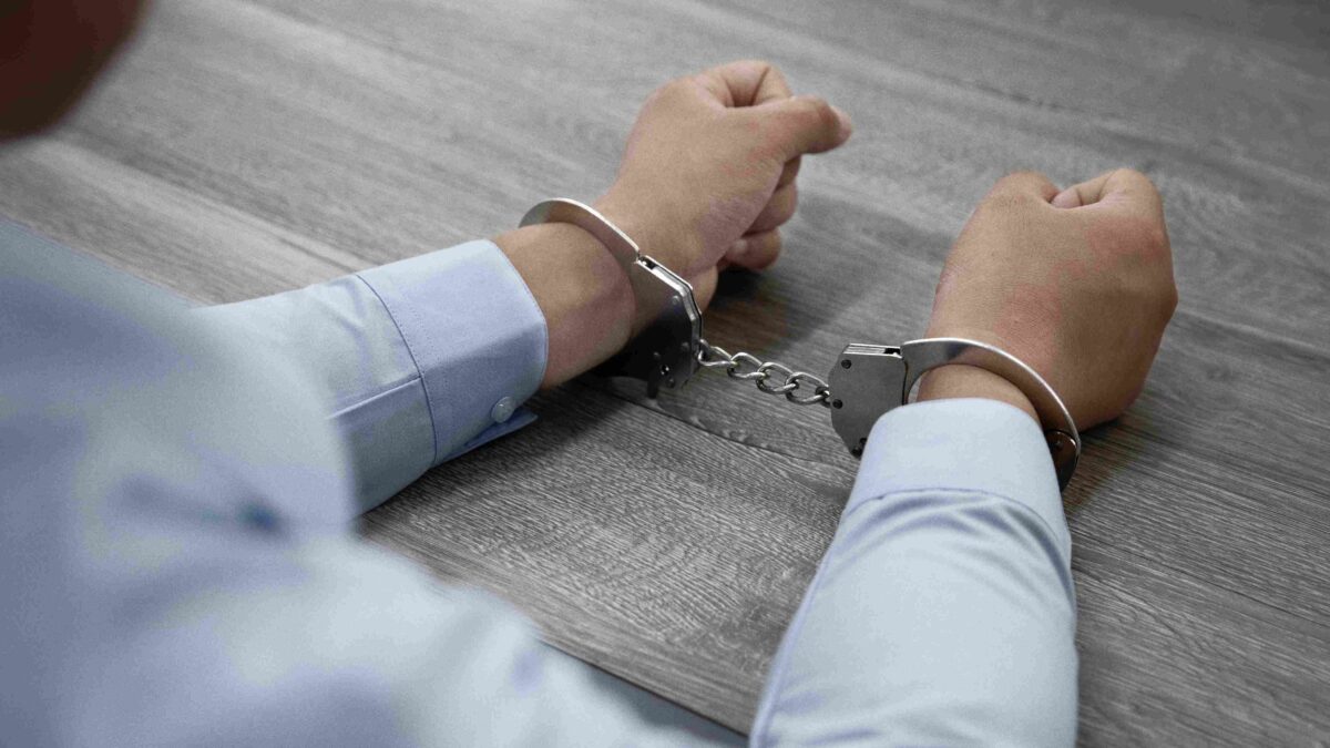 selective focus shot male hands handcuffs wooden table 11zon 1 selective focus shot male hands handcuffs wooden table 11zon