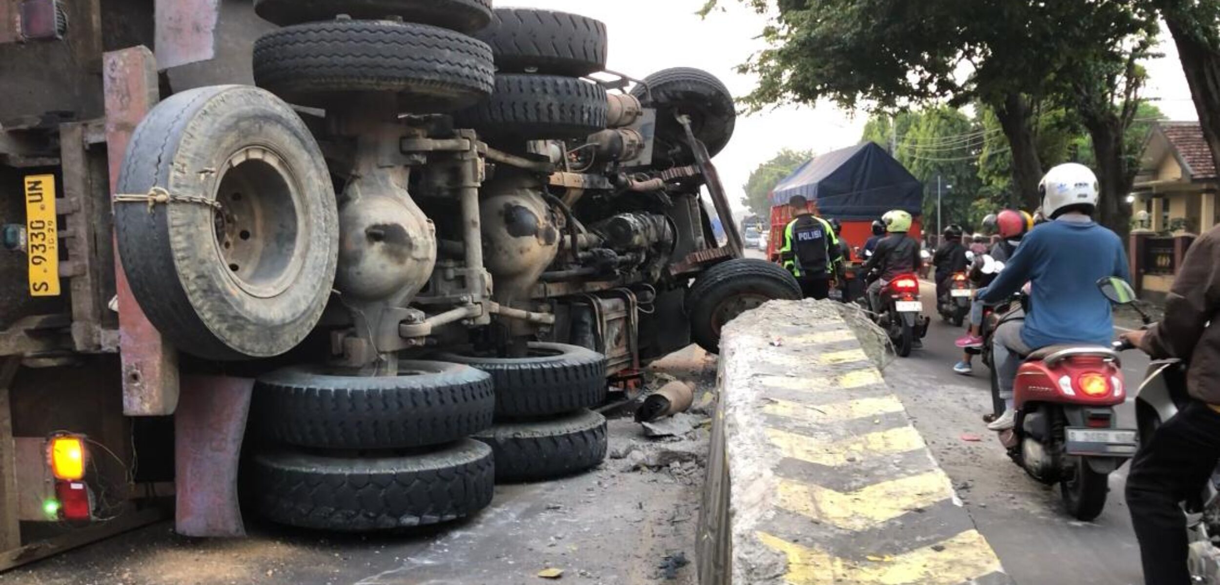 Terulang Lagi, Truk Terguling Usai Menabrak Pembatas Jalan depan SPN Polda Jatim