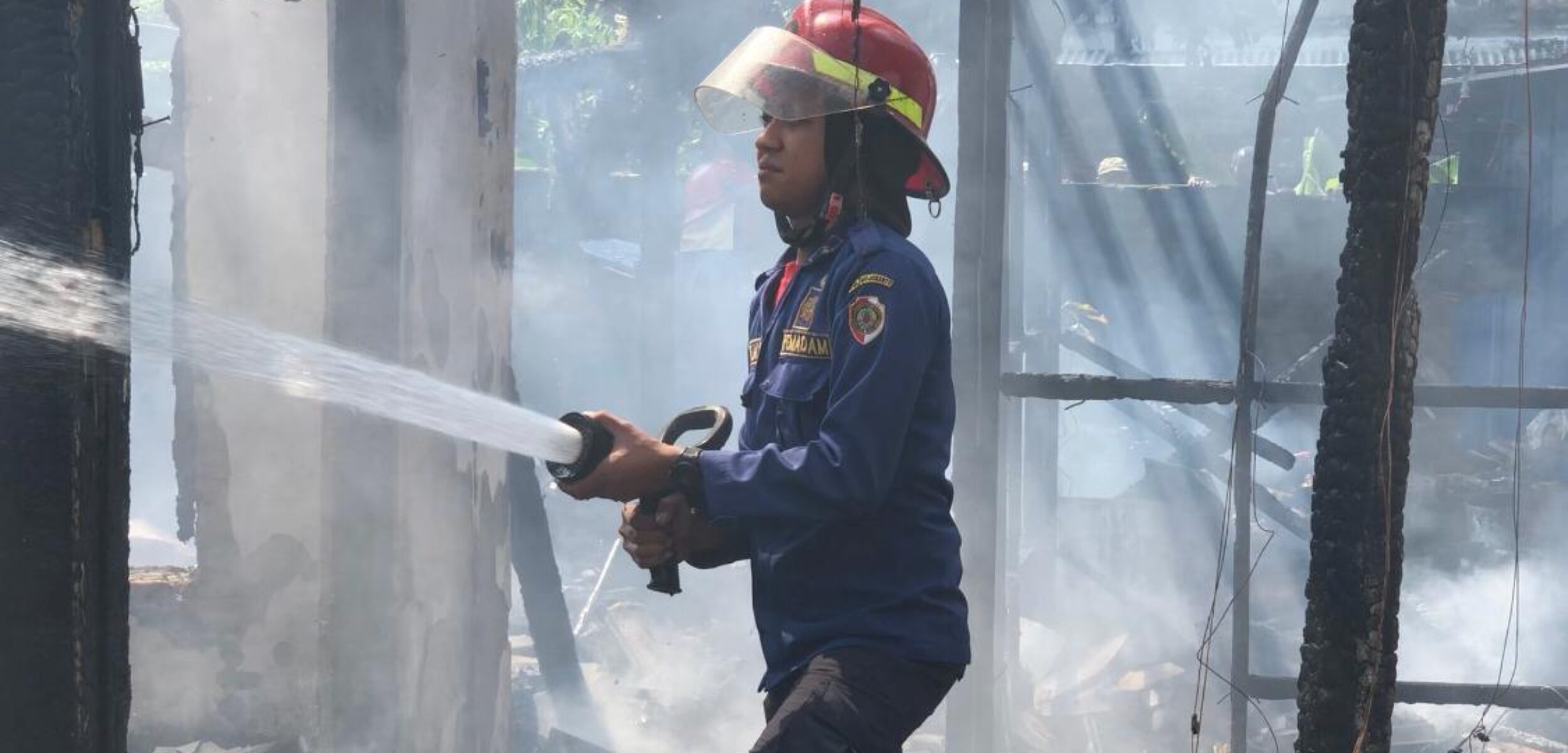 Petugas Damkar saat melakukan pembasahan sebuah rumah di dekat Pasar Dlanggu, Senin (5/5/2025) (Redaksi / Kabarterdepan.com) 