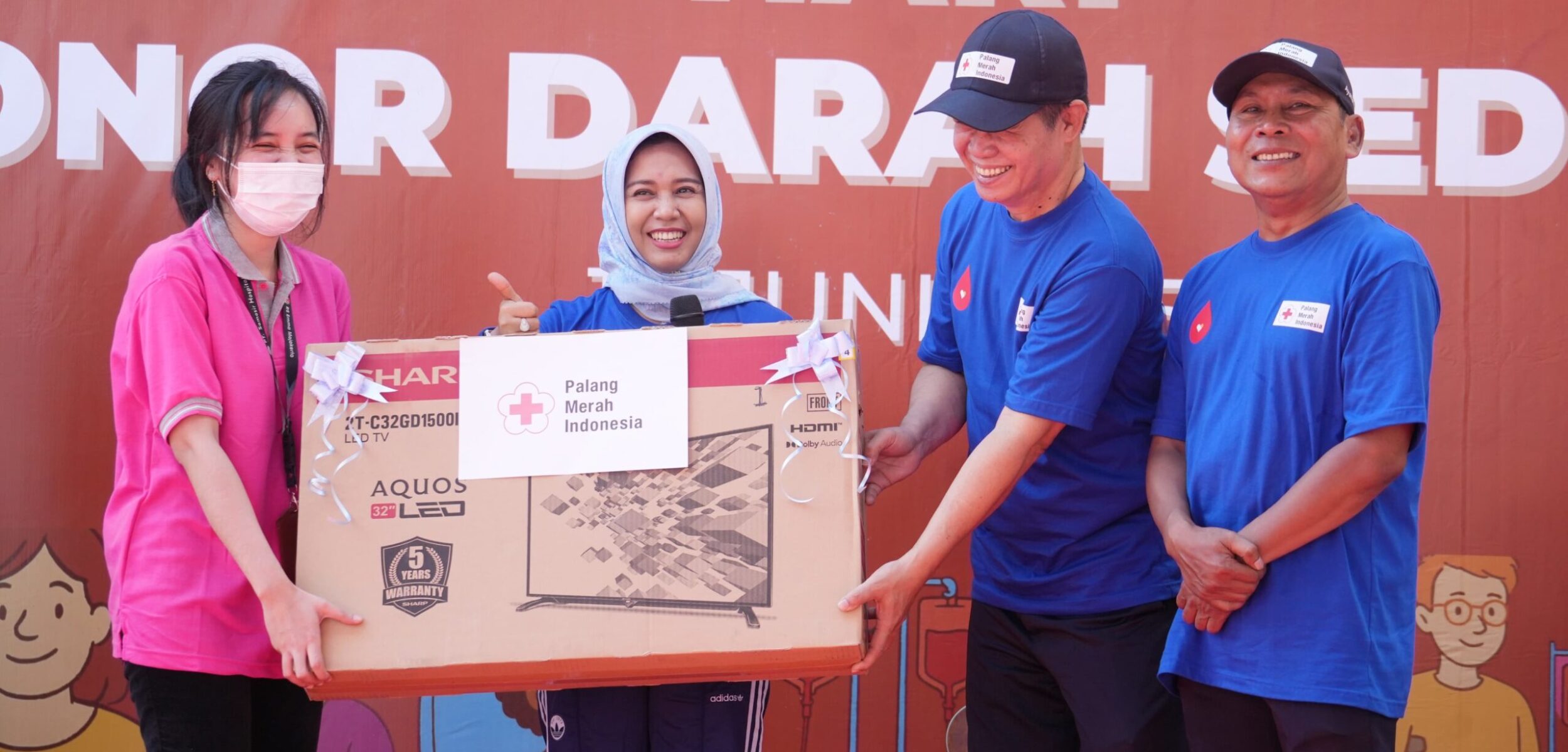 Wali Kota Mojokerto yang juga Ketua PMI Kota Mojokerto, Ning Ita didampingi pengurus memberikan hadiah Sharp TV LED 32 inch kepada pemenang doorprize (Redaksi / Kabarterdepan.com)
